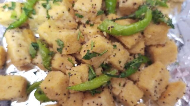 Top View Close-up of Spongy Gujarati Khaman Dhokla Garnished with Green Chillies