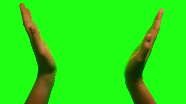 Close-up of hands clapping on green screen background. Applause gesture isolated on chroma key for editing and compositing. High quality 4k footage