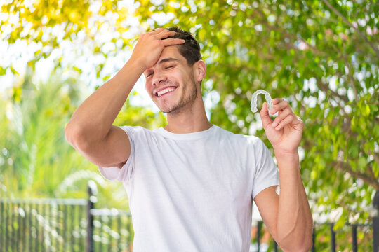 Young caucasian man holding invisible braces at outdoors has realized something and intending the solution