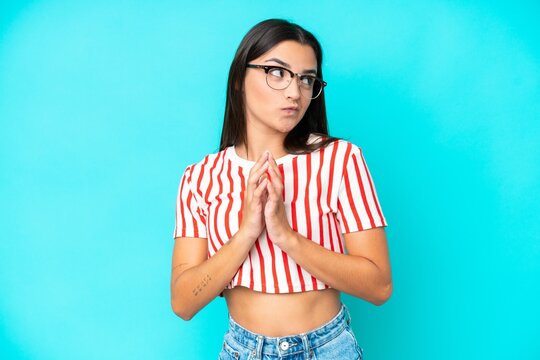 Young caucasian woman isolated on blue background scheming something