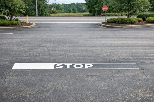 A stop sign painted on the ground in a parking lot, providing clear indication of traffic rules