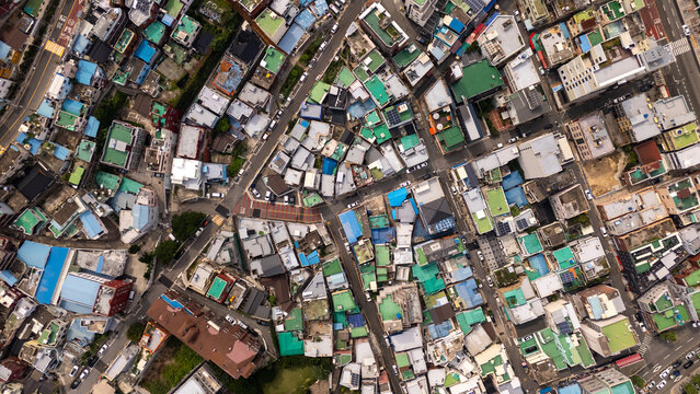 Aerial view of the dense urban landscape featuring a complex network of narrow streets, colorful rooftops, and residential buildings in Busan, Busan, South Korea.