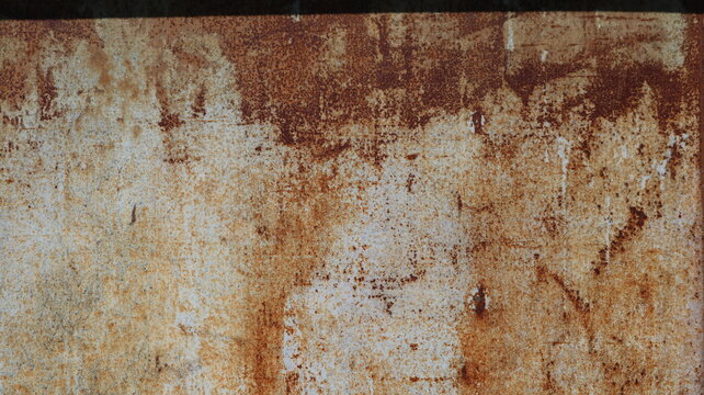 The flat texture of old iron, covered in a thick layer of oxidation. Red, brick, and brown streaks are visible on the gray-white base. The surface appears heavily eroded by time.