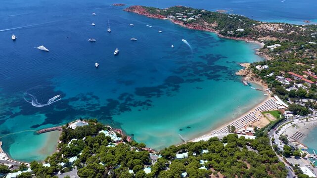 Aerial view of the popular Astir Beach in Vouliagmeni, south Athens coast, Greece, with turquoise sea and moored luxury yachts during summer time