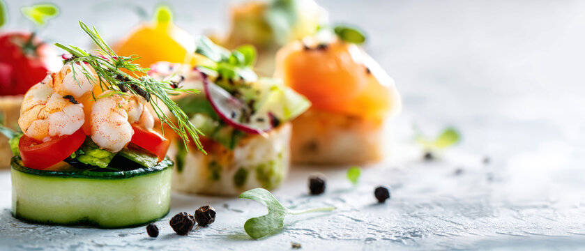 Buffet appetizers are arranged on a white surface with shrimp canapes, salad, and a vibrant tart. Space for text is on the left for catering purposes
