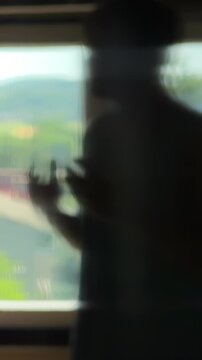 Depressed teenager in a dark room trying to discuss with his own reflection. Gesturing and giving himself a pep talk for motivation and confidence