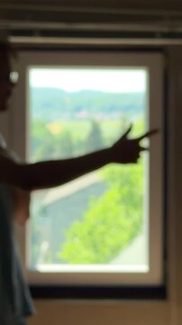 Depressed teenager in a dark room trying to discuss with his own reflection. Gesturing and giving himself a pep talk for motivation