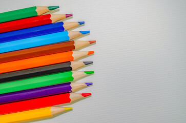 Fototapeta premium Colorful pencils lying on watercolor paper Copy space for text or design. Bright stationery composition perfect for school, creativity, drawing and educational concepts. Back to school concept