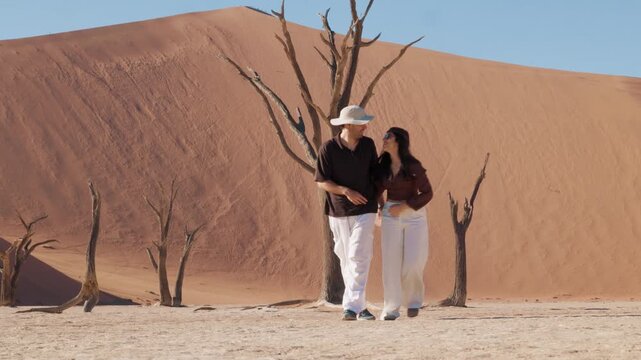 Romantic couple walking together in Sossusvlei Namibia desert