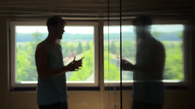 Depressed teenager in a dark bedroom trying to argue with his reflection and despairing. Dissociative identity disorder
