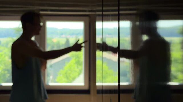 Depressed teenager in a dark room trying to discuss with his own reflection. Gesturing and giving himself a pep talk for motivation