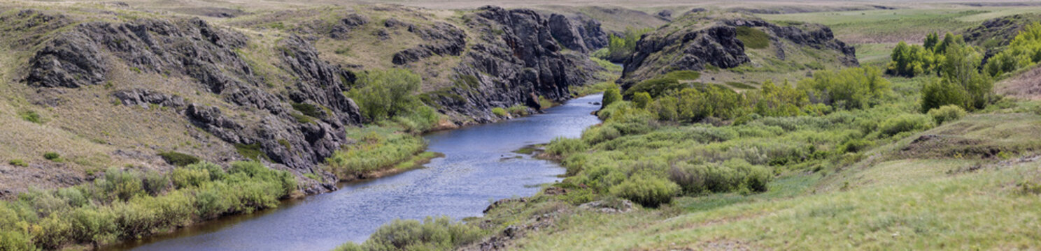 Panoramic view of a river in a rocky gorge on a sunny day.
