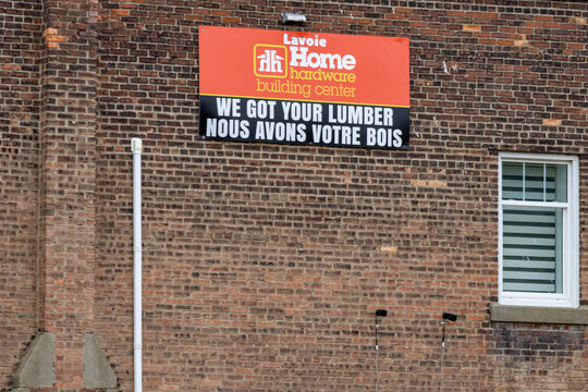 Gaspesie, Quebec, 06 June 2026 : A sign for Lavoie Home hardware building center advertises lumber on a brick wall.