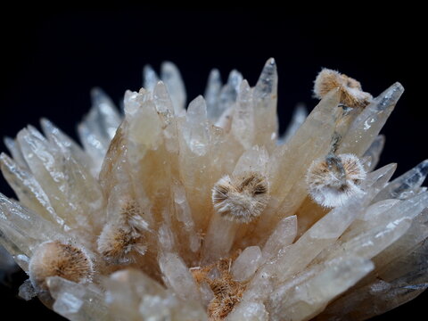 A close-up of sharp calcite crystals accented by fuzzy zeolites.
