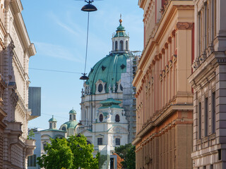 Majestic St Charles Church architecture viewed down a historic Vienna city street with green domes © Mujie