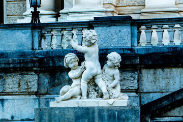 Naklejka premium Three Cherubs Stone Sculpture on a Palace Staircase Representing Innocence and Classical Art History