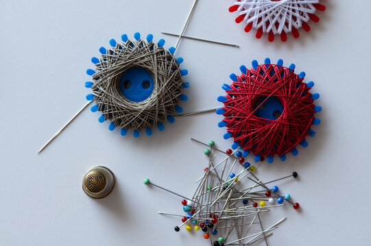 Various sewing supplies, Sewing thread spools, sewing needles, pins and thimble