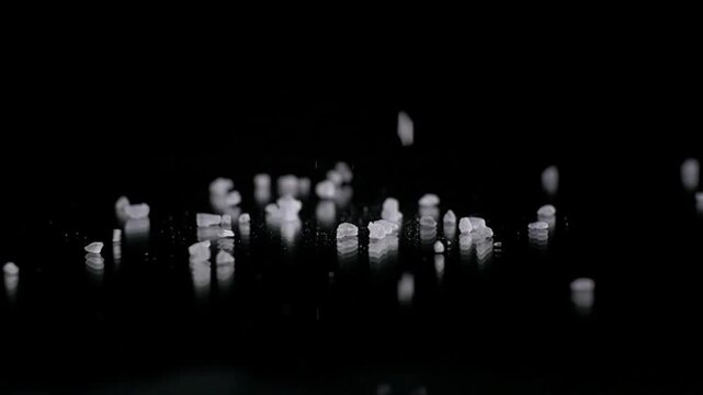 Salt Crystals Falling in Slow Motion on Dark Background