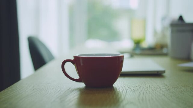 Close-up of Business Man Placing Red Coffee Cup on Desk and Opening Laptop to Work, Reply Emails, and Check News, Morning routine.