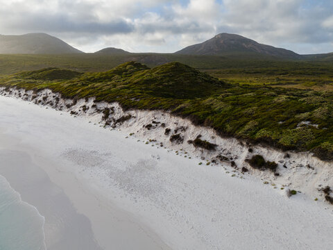 Aerial view of Hellfire Bay with white sand dunes, turquoise water, and coastal vegetation in Cape Le Grand National Park, Western Australia, Australia.