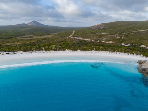 Aerial view of Hellfire Bay featuring turquoise waters, white sandy beach, and surrounding coastal vegetation in Cape Le Grand National Park, Western Australia, Australia.