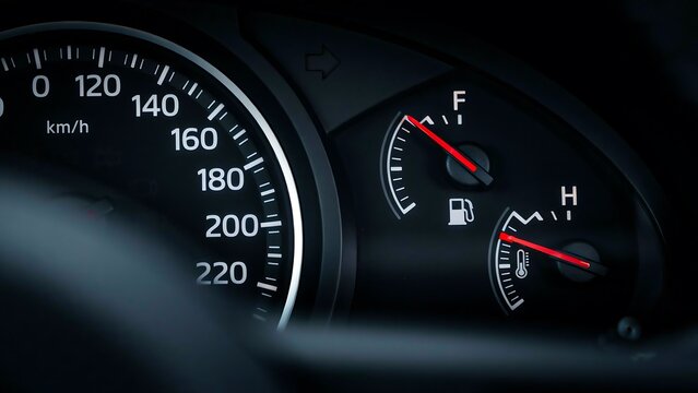 Car dashboard showing fuel gauge and engine temperature indicators