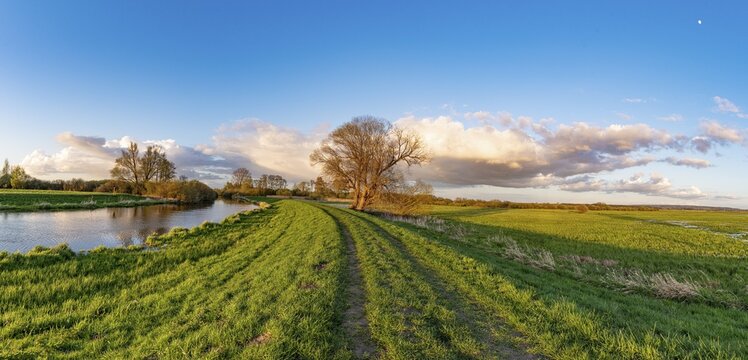 The Hunte river near its mouth in D&uuml;mmer See, landscape with river and meadow path under blue sky and clouds, D&uuml;mmet nature park Park, Lower Saxony, Germany