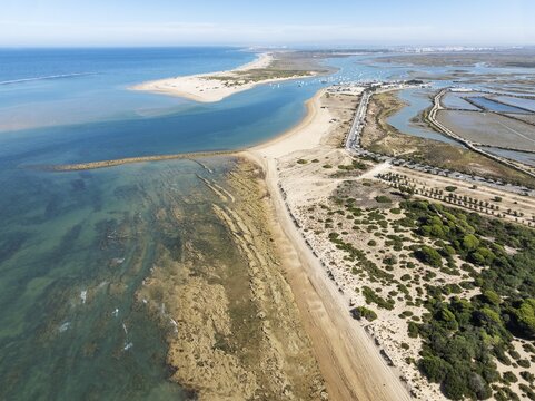 Aerial view of the Atlantic Coast with the fishing village of Sancti Petri, the large sandbar of Punta del Boquer&oacute;n and the surrounding marshes at low tide. In the distance the town of San Fernando. Drone shot. Bah&iacute;a de C&aacute;diz Nature Reserve. C&aacute;diz province, Andalusia, Spain