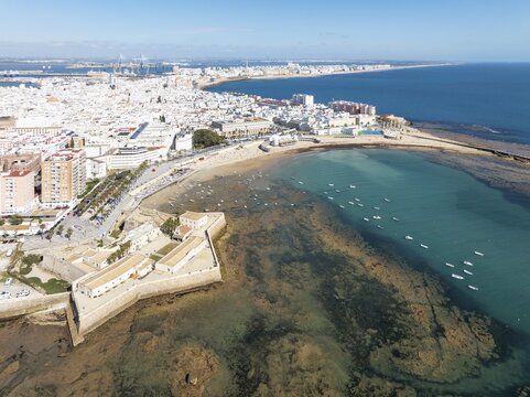 The town of C&aacute;diz with the old quarter in the foreground. Prominent the Santa Catalina castle, the Caleta beach, the old Balneario de la Palma and the fishing boats at low tide. Aerial view. Drone shot. C&aacute;diz province, Andalusia, Spain