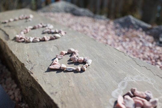 石の上に並べられた小石のハートアート  
Heart‑shaped stone arrangement on a flat rock surface
