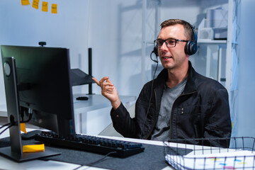 Male Technical Help Desk Agent Helping a Client Solve an IT Problem Through Headset Communication....