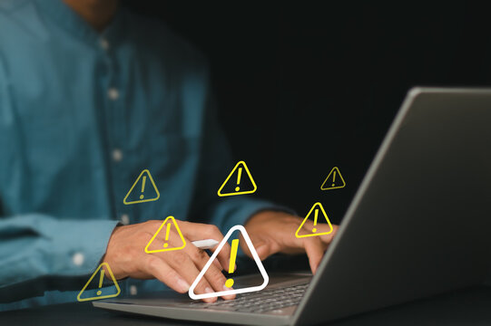 Cybersecurity risk concept. Person using laptop with warning alert and security icons, system notifications, data protection, human error prevention and cyber risk management.