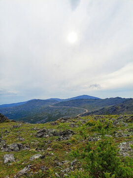 Mountain landscape in the summer. View from the top of the mountain to the road through the mountains pass
