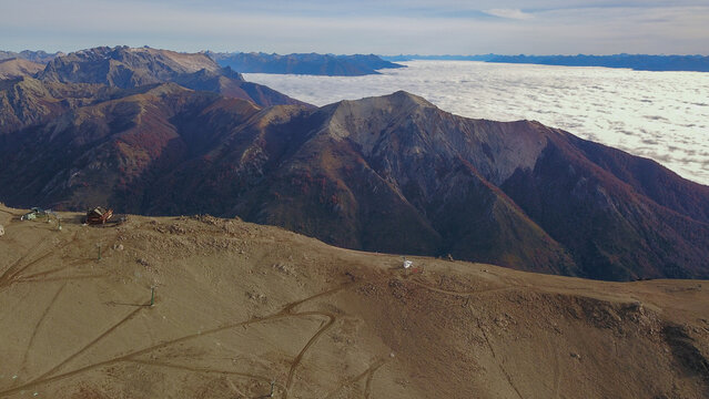 Aerial view of the rugged mountain peaks and ski slopes of Cerro Catedral with a sea of clouds in the distance in San Carlos de Bariloche, Rio Negro Province, Argentina.