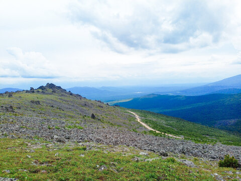 Mountain landscape in the summer. View from the slope of the mountain to the road through the mountains pass