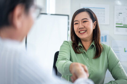 Professional business woman shakes hands creating successful environmental conservation partnership agreement in modern corporate office fostering sustainability growth