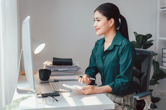 Asian Woman Working at Desk with Computer Calculator and Pen Acc