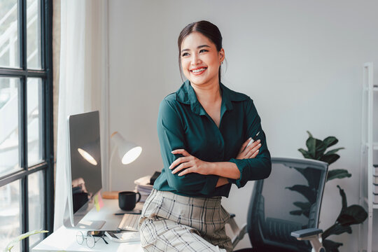 Confident Asian Business Woman Smiling in Modern Office Setting