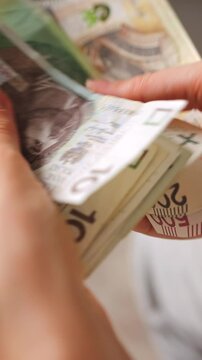 Female hands carefully counting polish zloty banknotes