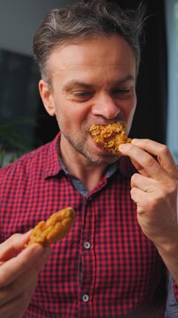 Junk food advertisement concept. Man eating fried chicken, enjoying fast food.