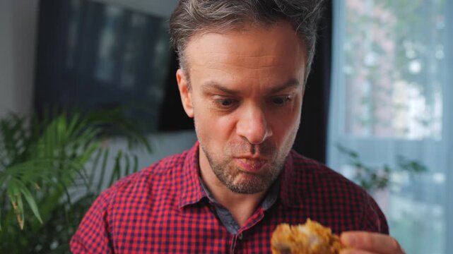 Junk food advertisement concept. Man eating fried chicken, enjoying fast food.