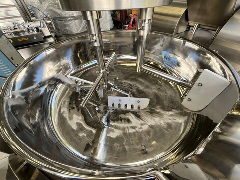 Close-up of the stainless steel bowl and cutting system inside an industrial bowl cutter used in food manufacturing. High-capacity food processing equipment designed for chopping, mixing, and emulsify