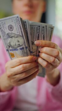 Woman counting US Dollar bills, close-up. Concept of investment and success