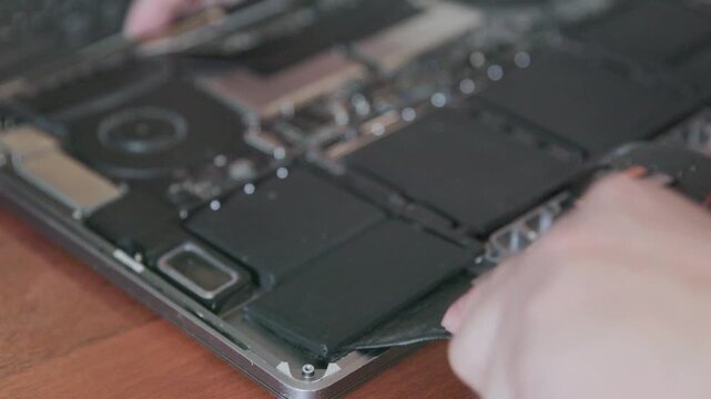 Blurred close-up of the open case of a modern laptop being repaired