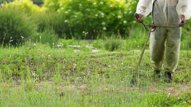 Close-up shows hands guiding cultivator through tall grass. Tool uproots weeds from soil. Gardener walks away after maintenance. Sunlight illuminates garden scene