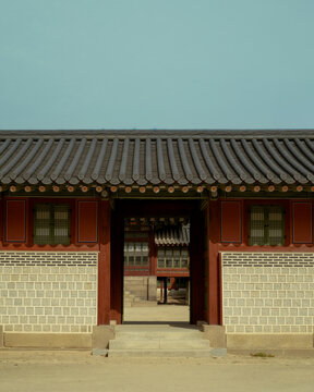 Traditional Korean palace gate with tiled roof and decorative wall seen through an open doorway, Seoul, South Korea