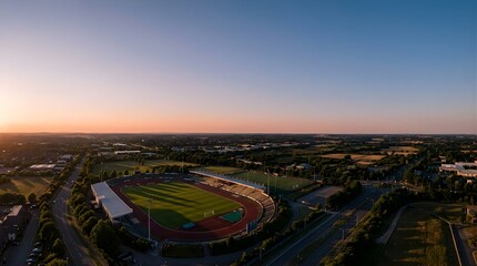 Fototapeta premium Aerial view of a sports stadium and running track at sunset