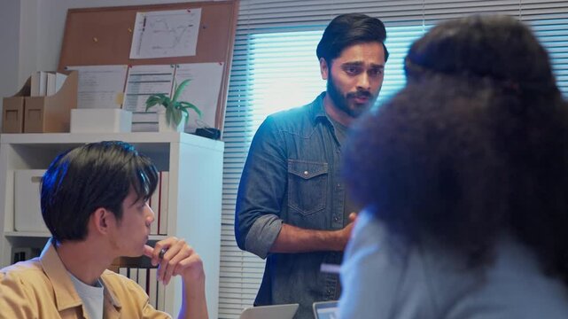 Diverse business team standing in office at night analyzing ESG strategy and clean energy solutions, multiracial analysts discussing sustainable growth plan, corporate consulting concept