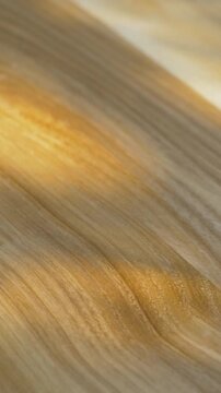 Glistening varnish covers wooden surface, highlighting rich texture and fine details. Smooth layer provides lasting protection while amplifying warmth of natural material