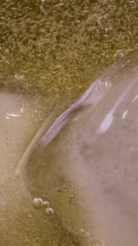 Cold cider poured into glass. Bubbles dance and foam forms gently. Natural choice for relaxing evening, complementing flavors of freshly baked bread and creamy dips for perfect combination
